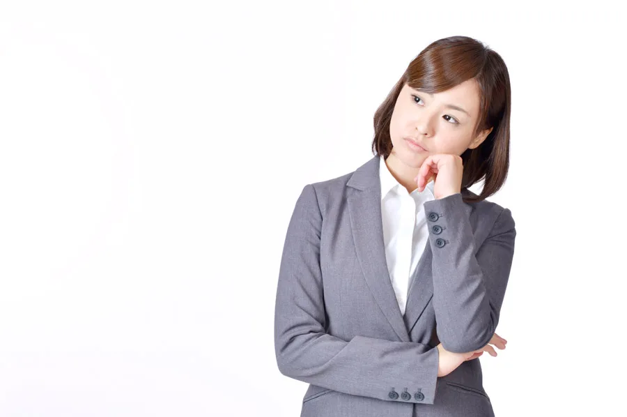 悩むスーツ姿の女性