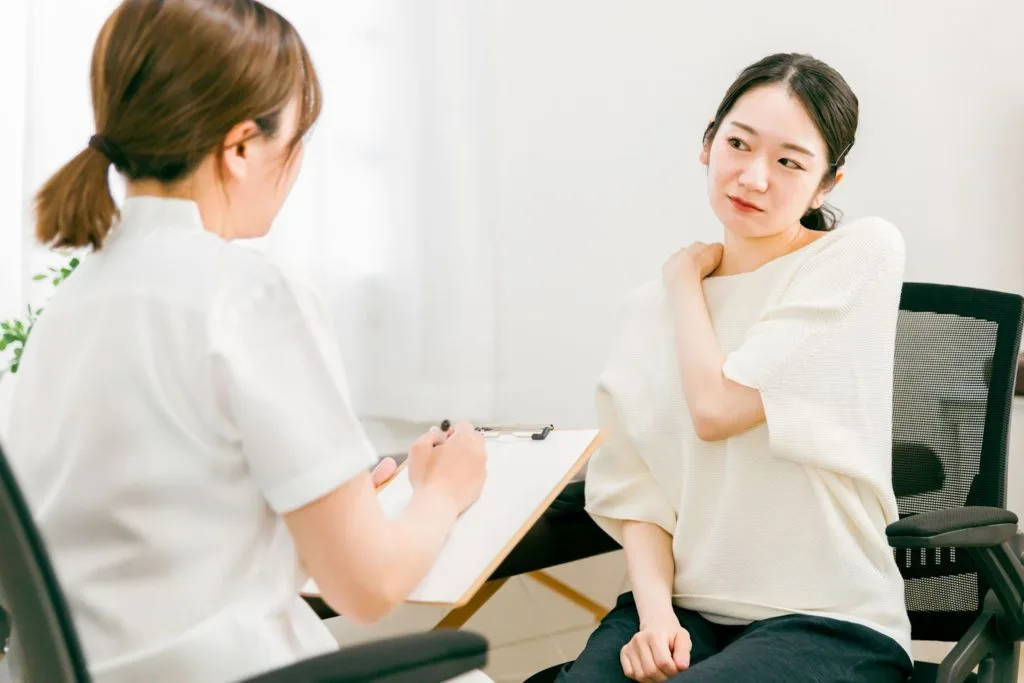 肩の不調を訴える女性