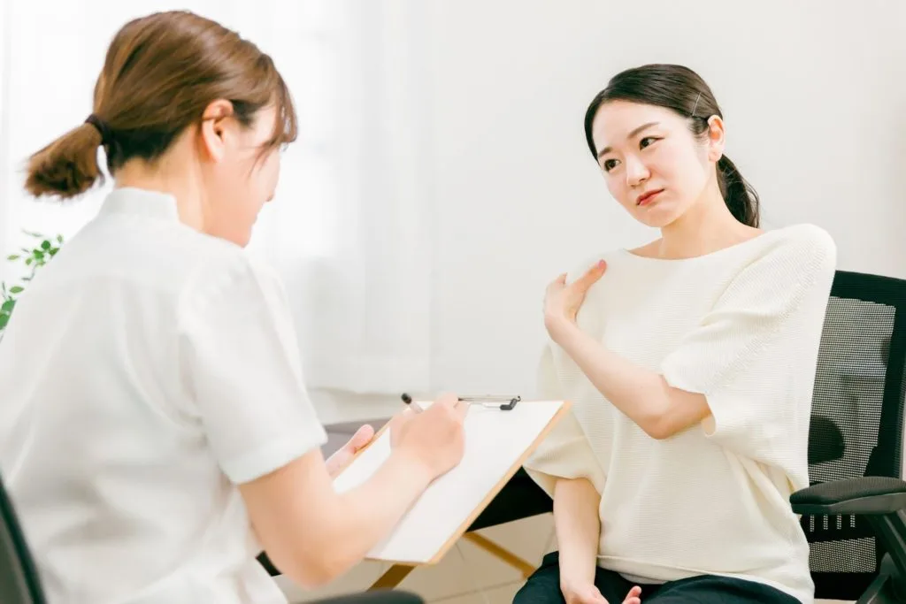 方の悩みを整体師に相談する女性