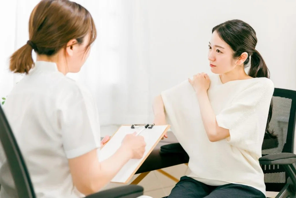 肩の違和感を相談する女性