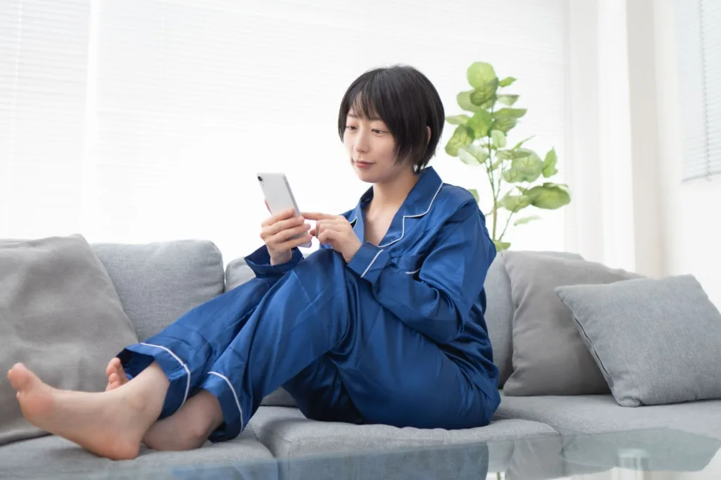 パジャマでスマホを触る女性