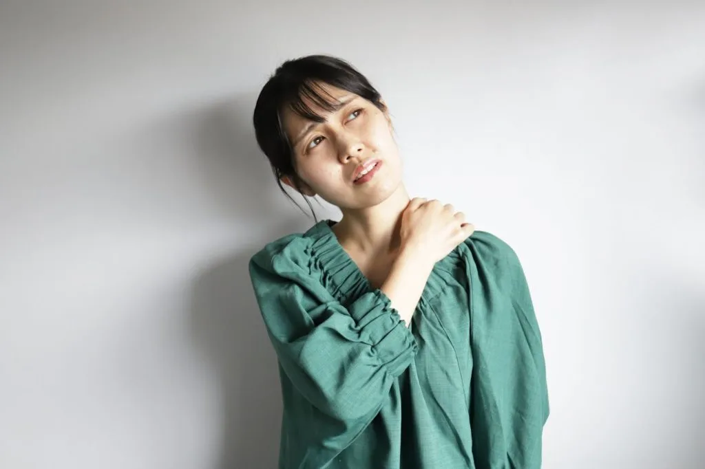 左肩を押さえる女性