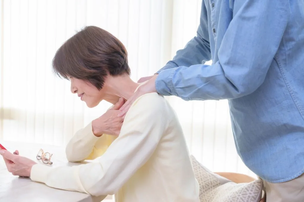 肩を揉んでもらう女性