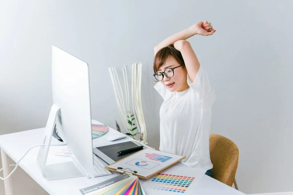 座りながら背筋を伸ばす女性