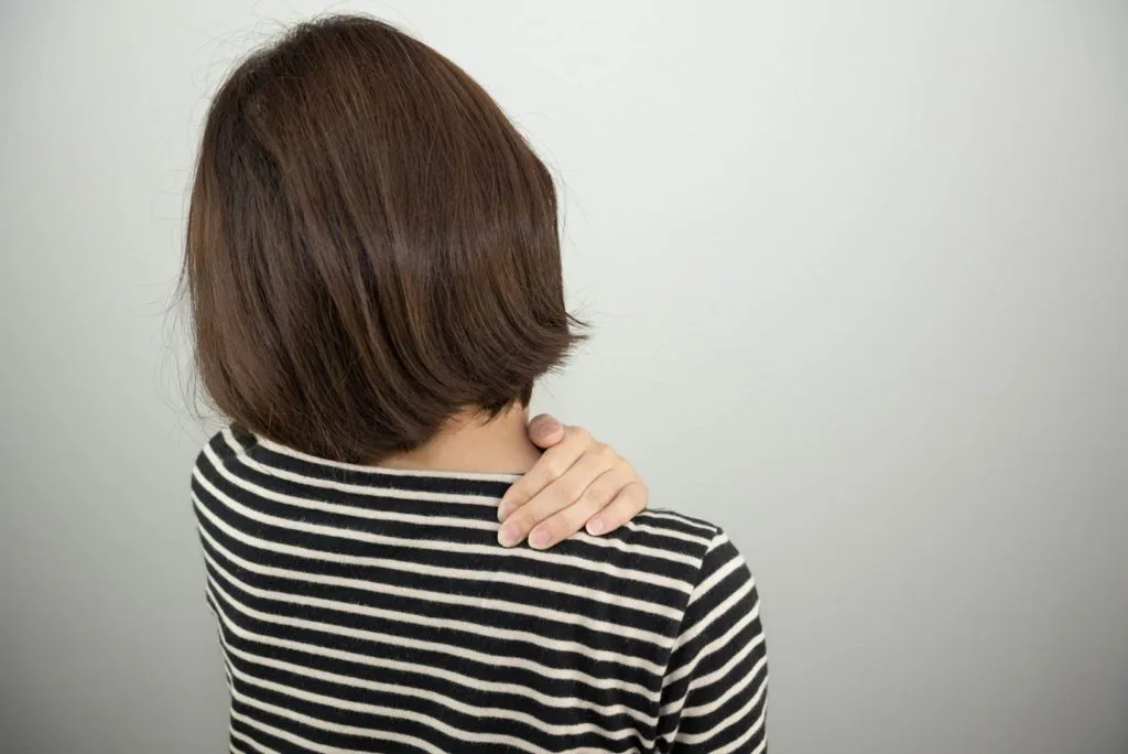 右肩を押さえる女性