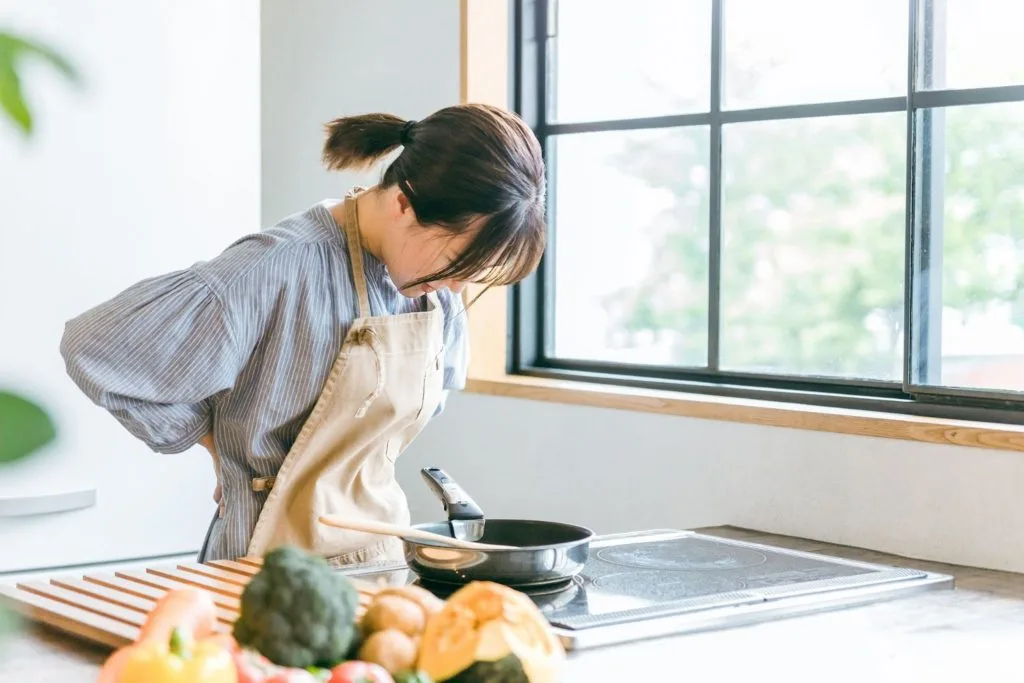 料理中に腰の辺りを気にする女性