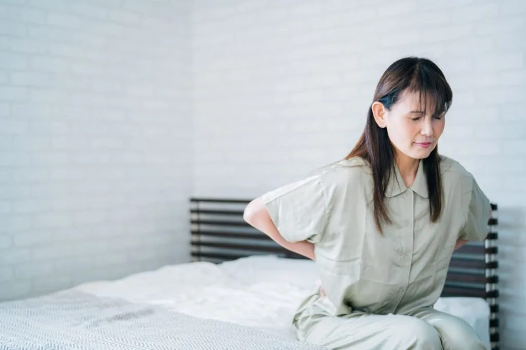 腰の辺りを気にする女性
