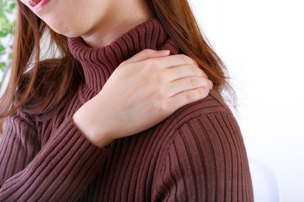 肩を押さえる女性