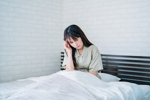 寝起きの腰痛に悩む女性