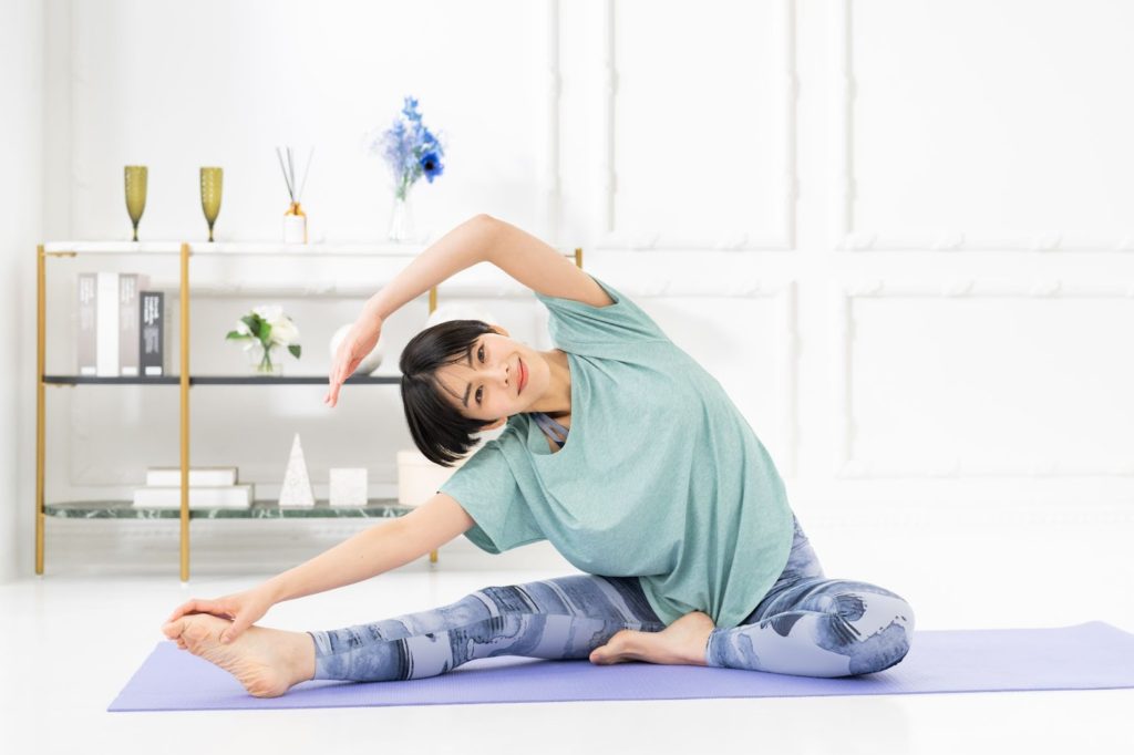 マットの上でストレッチをする女性