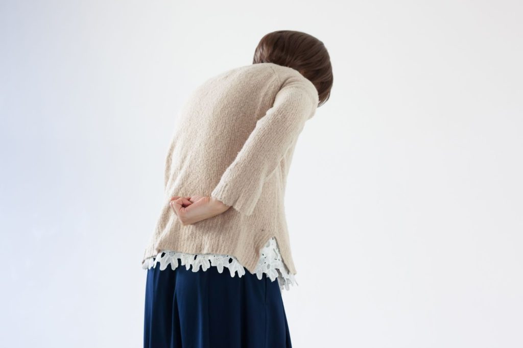 腰の辺りを気にする女性
