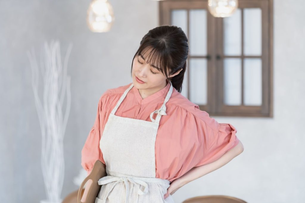 腰の辺りを気にする女性