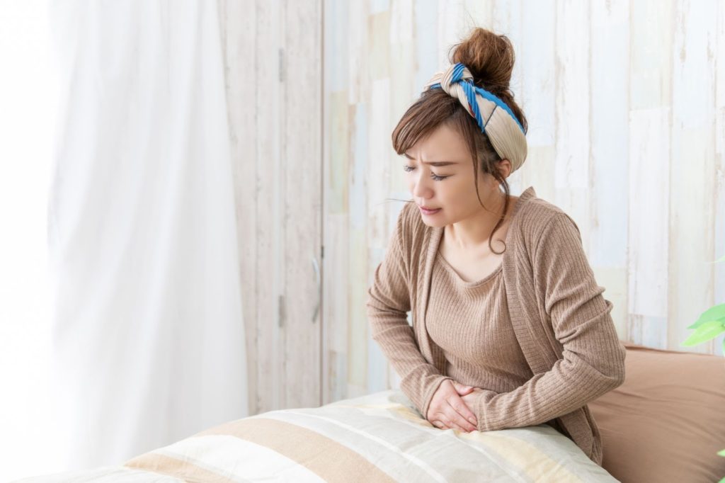 お腹の痛みを気にする女性