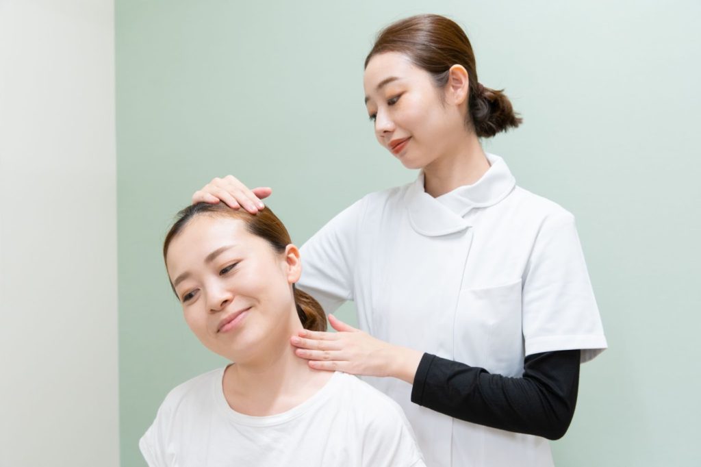 首の辺りを施術してもらう女性