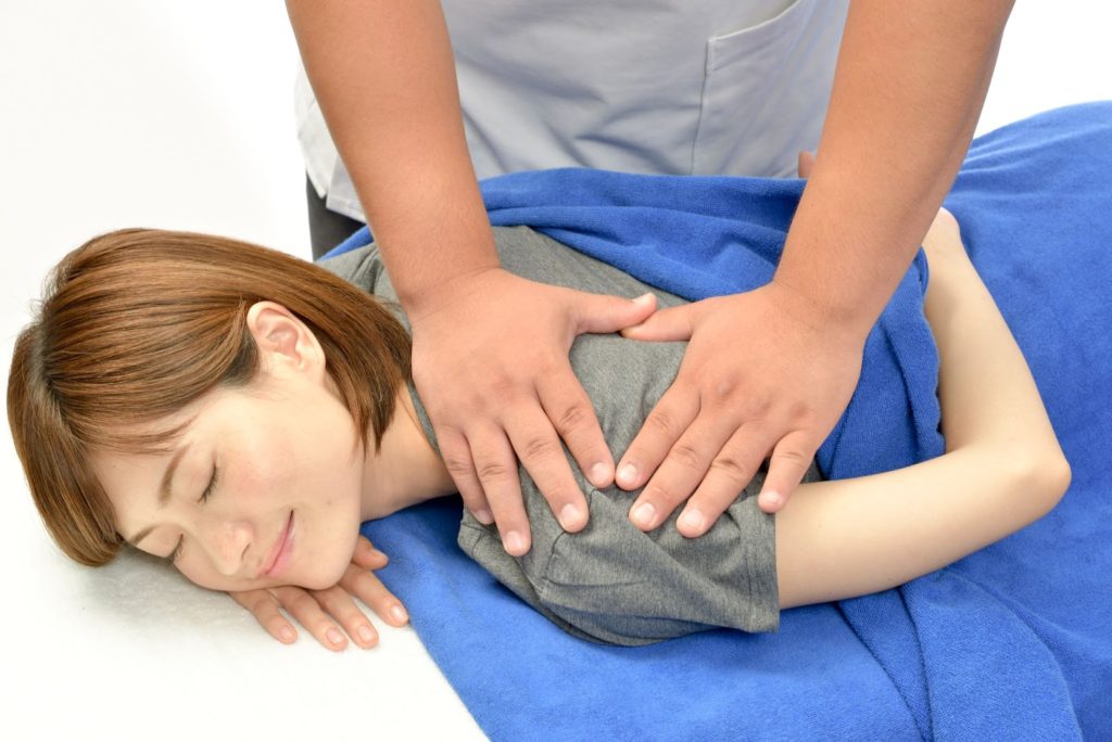 肩の辺りを施術してもらう女性