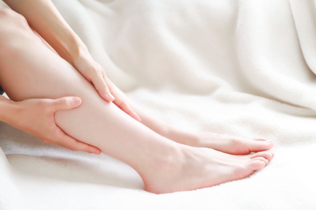 ふくらはぎの辺りを抑える女性