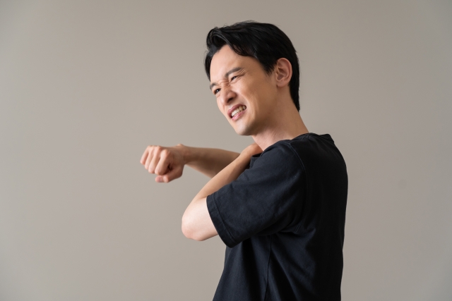 肩の痛みを感じる男性